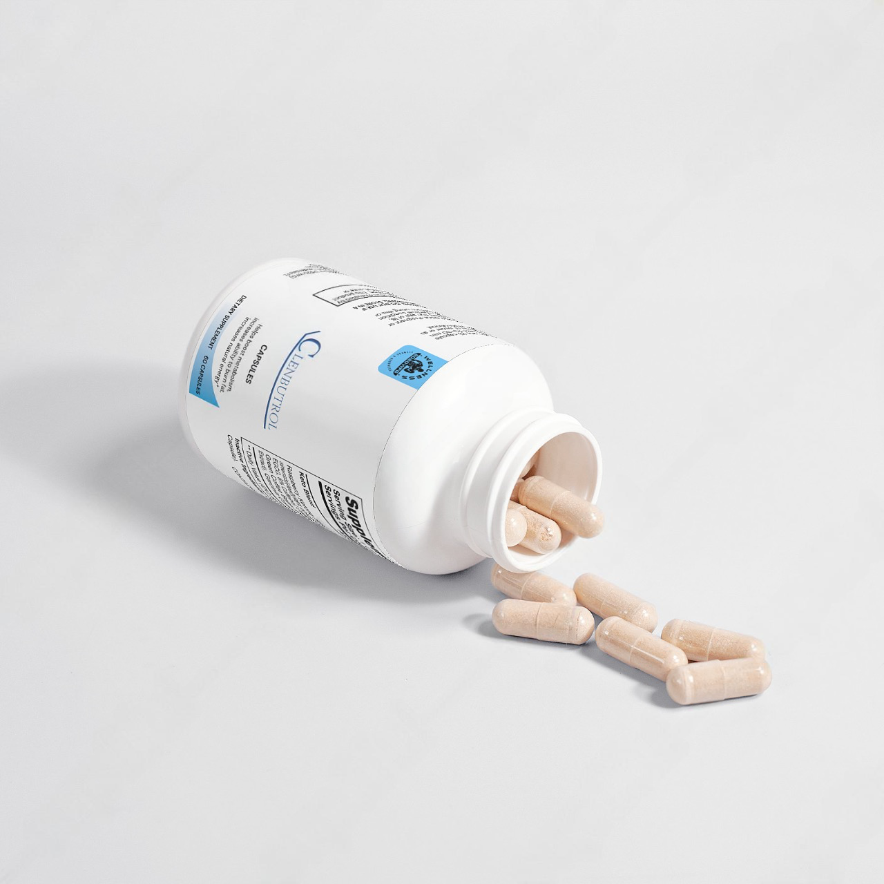 A white bottle of 2020WFG's CLENBUTROL dietary supplement capsules is tipped over, spilling beige capsules designed to promote lean muscle growth. The blue label contrasts with the plain light gray background, emphasizing its qualities as an effective fat-burning supplement.